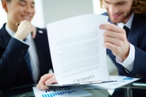 Two successful entrepreneurs reading and discussing business contract